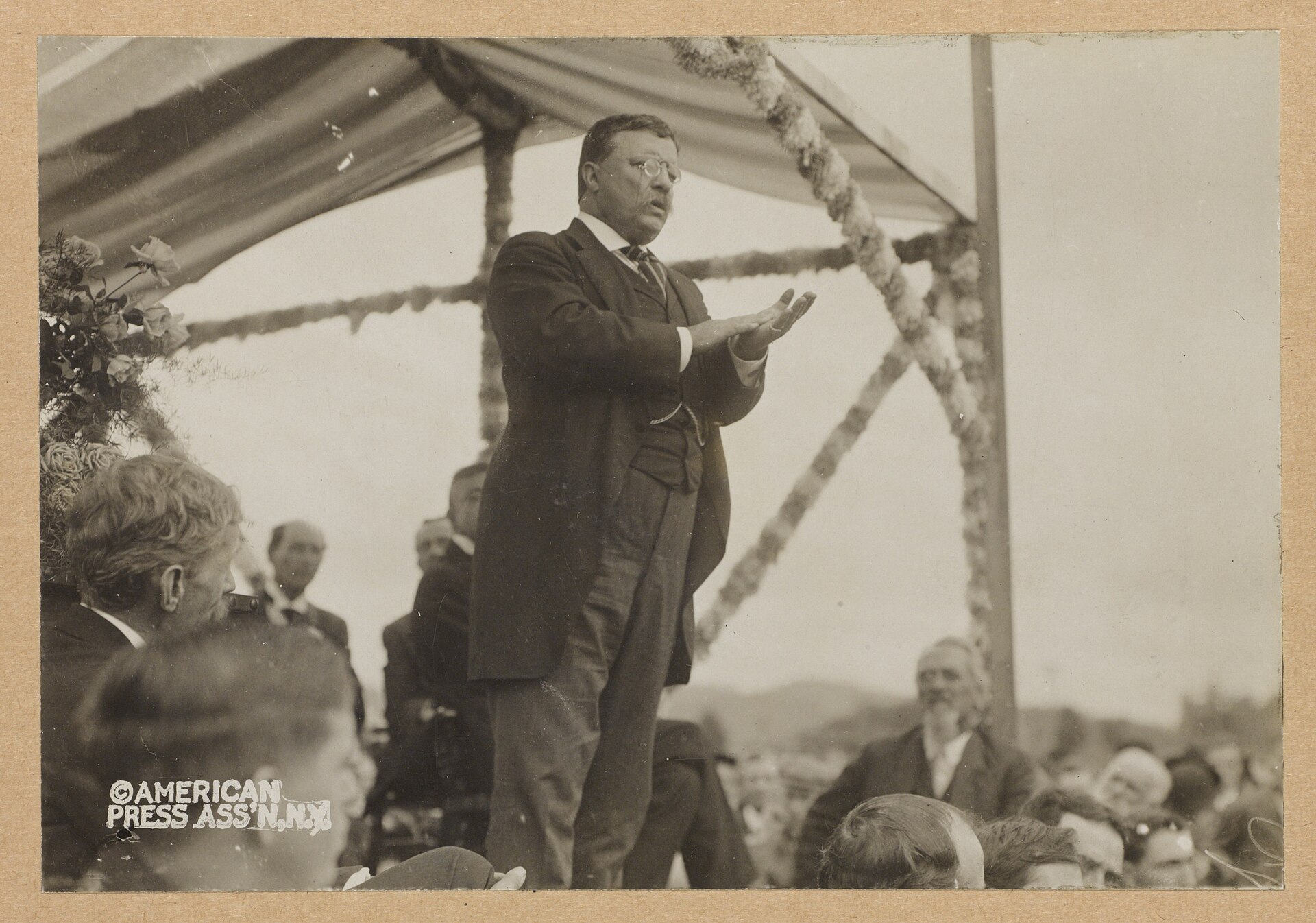 Theodore Roosevelt speaking to a crowd from a platform