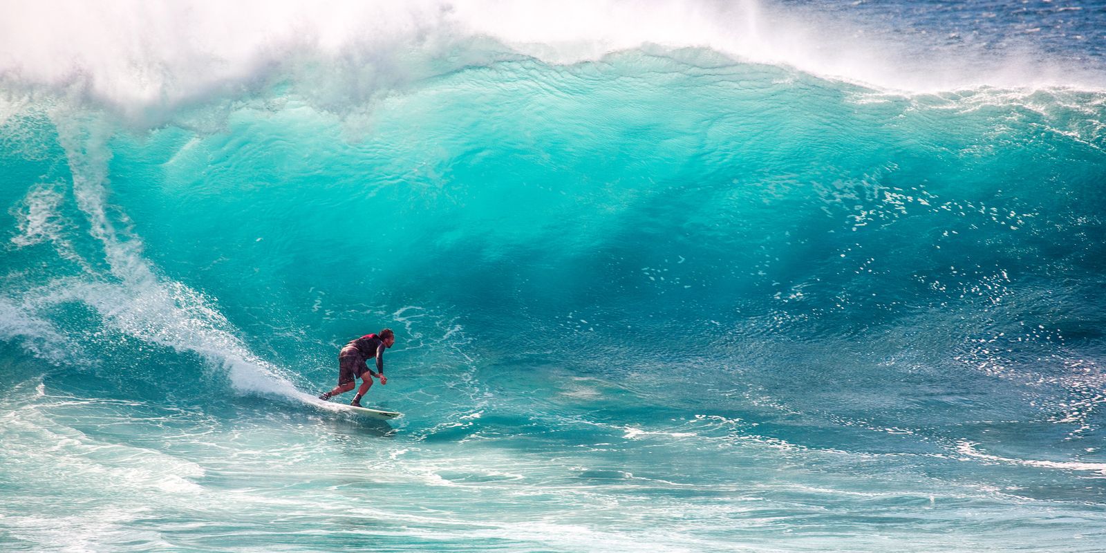 A surfer under a breaking wave